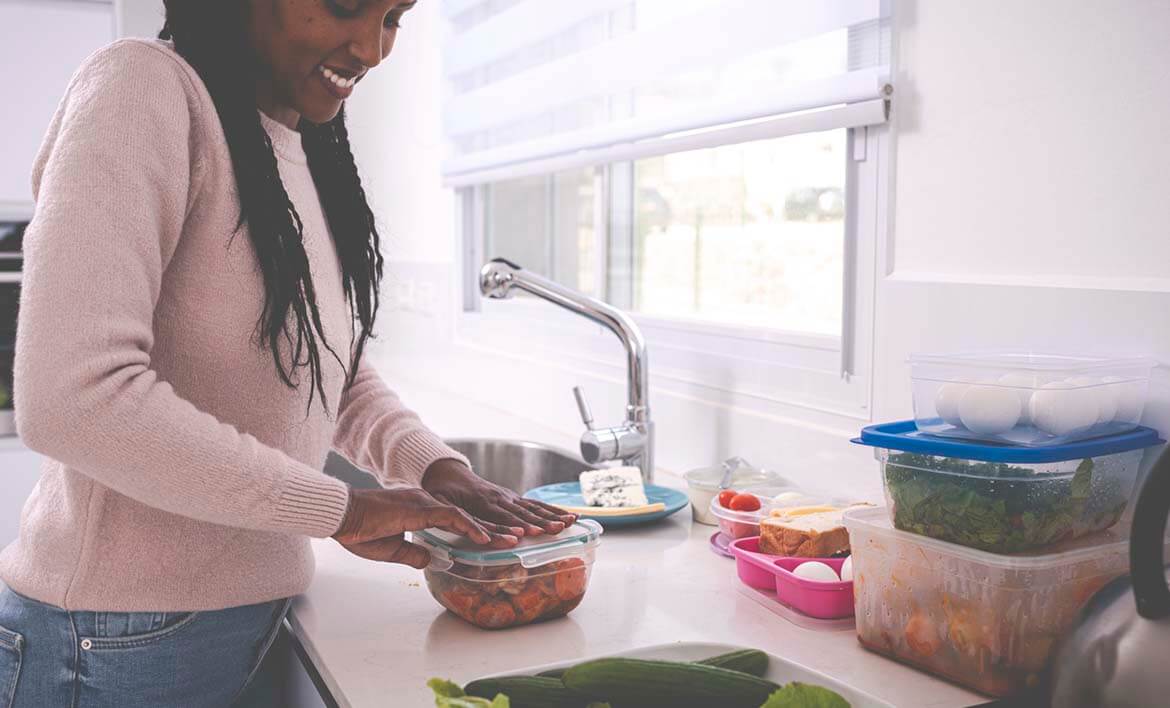 Using up leftovers - woman packing leftovers into containers