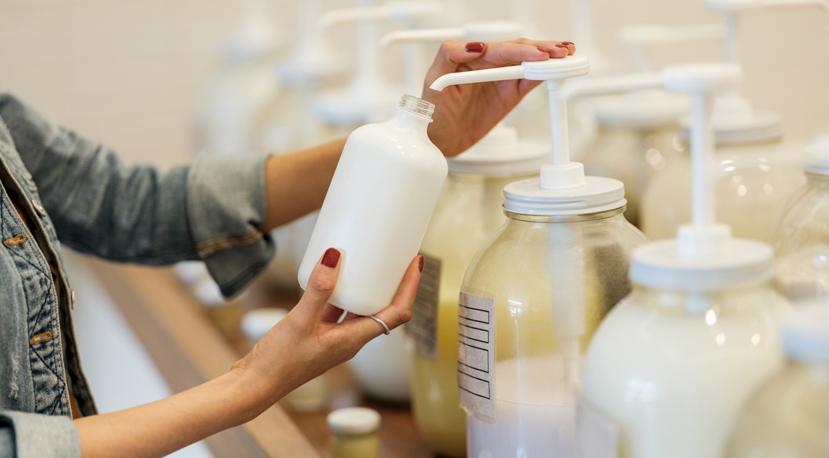 A lady using a reusable container to purchase a cleaning product