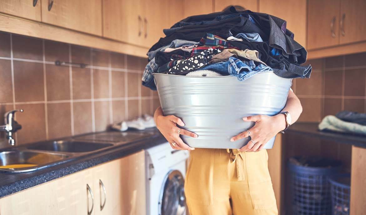 Woman holding a pile of clothes