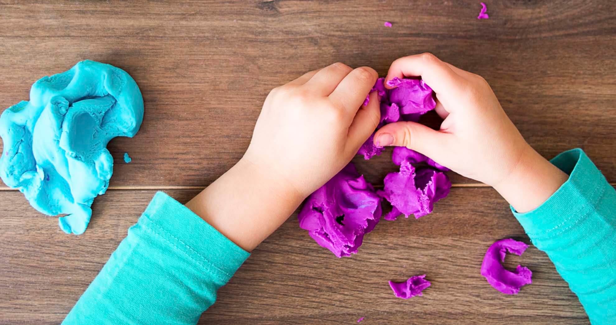 Child's hands playing with playdough