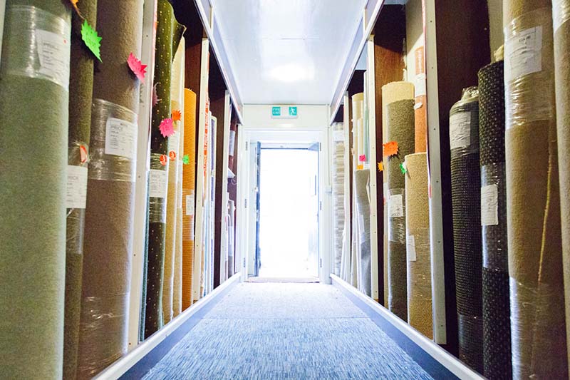 Photo of rows of rolled up carpets in a store