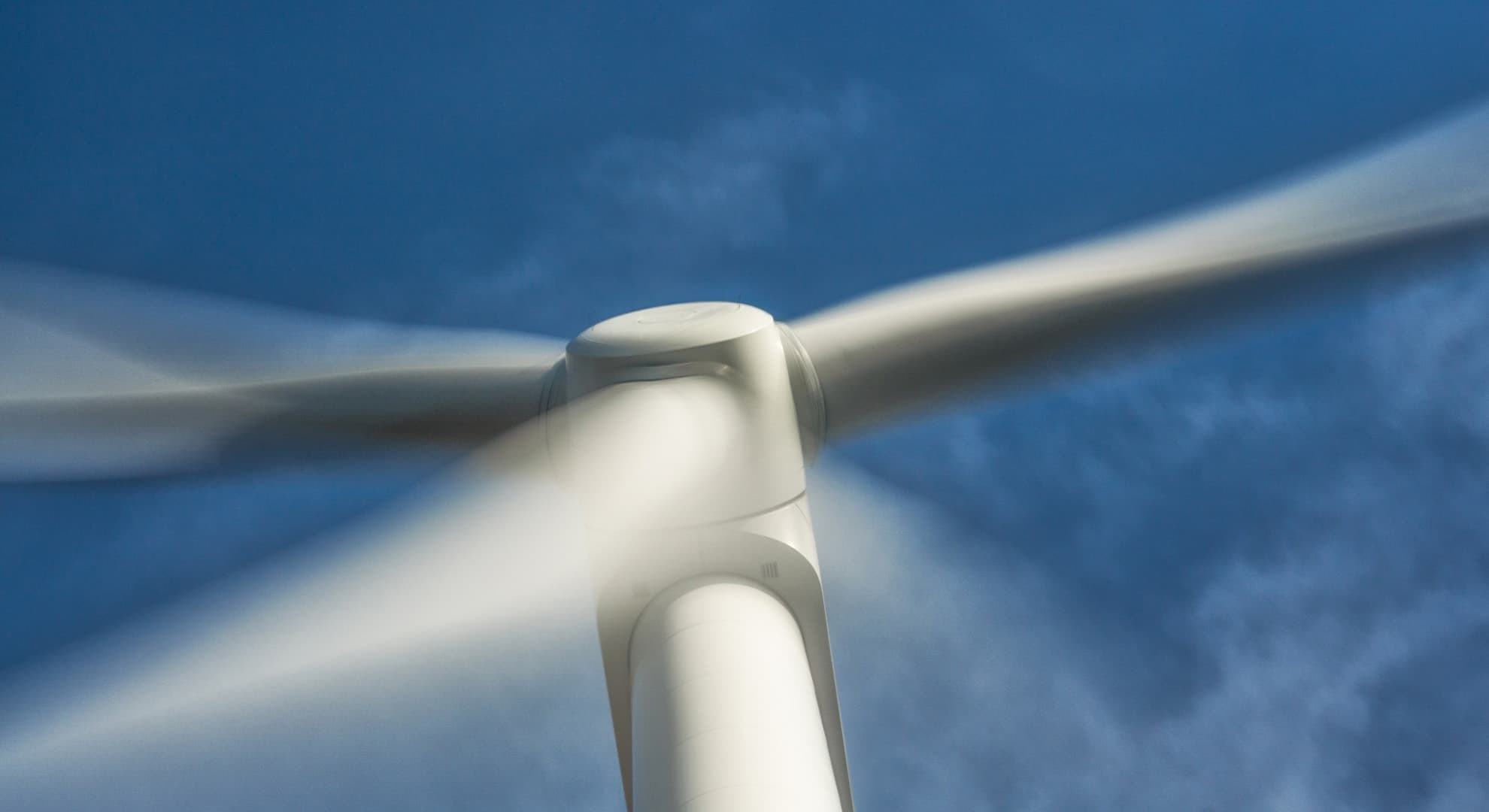 wind turbines spinning with blue skies in the background