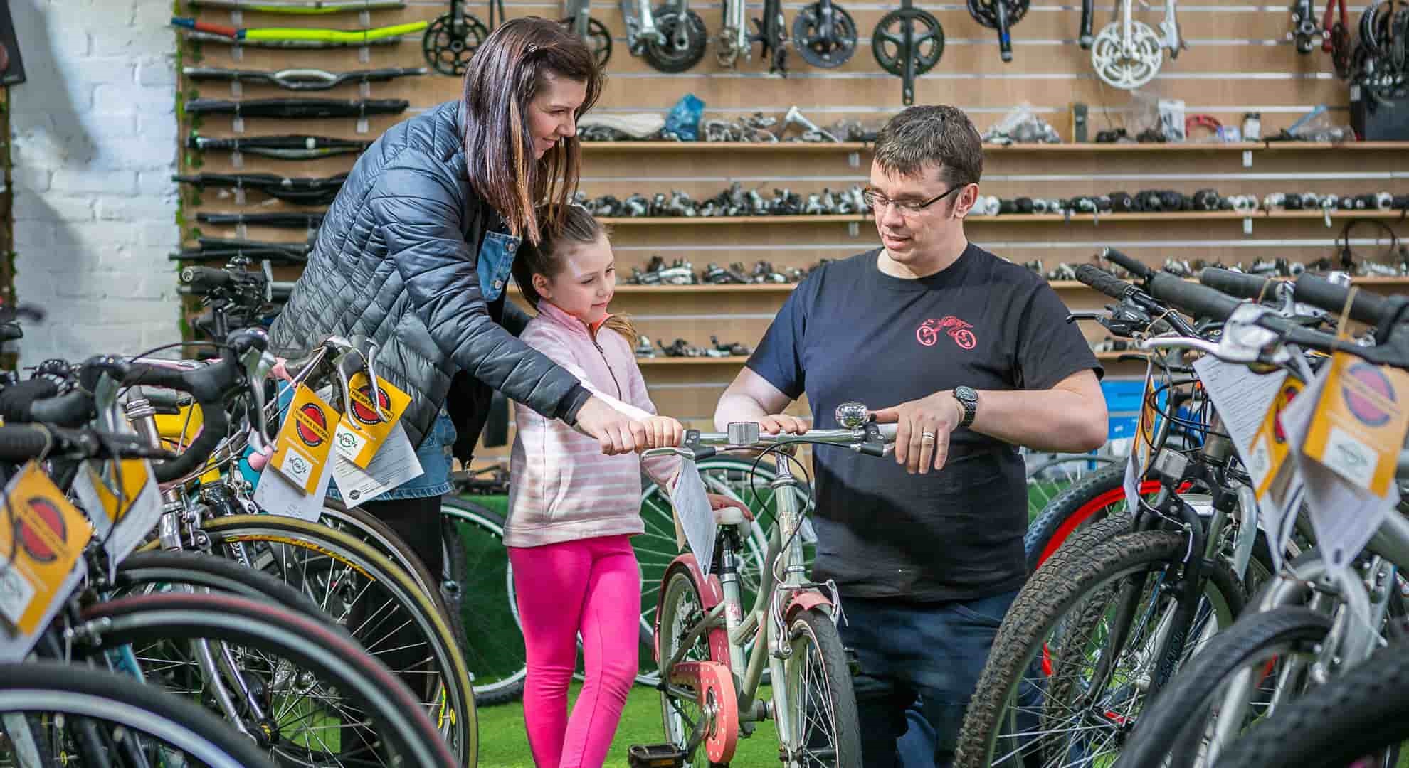 child trying out a bike in a second hand store