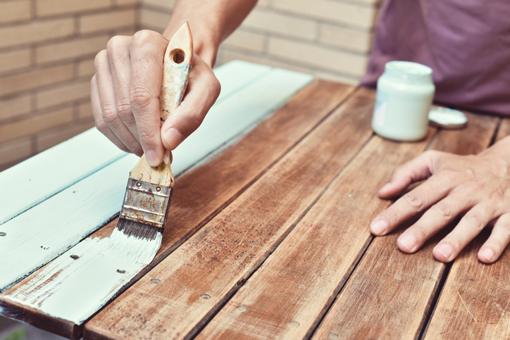 A person upcycling a table by painting it