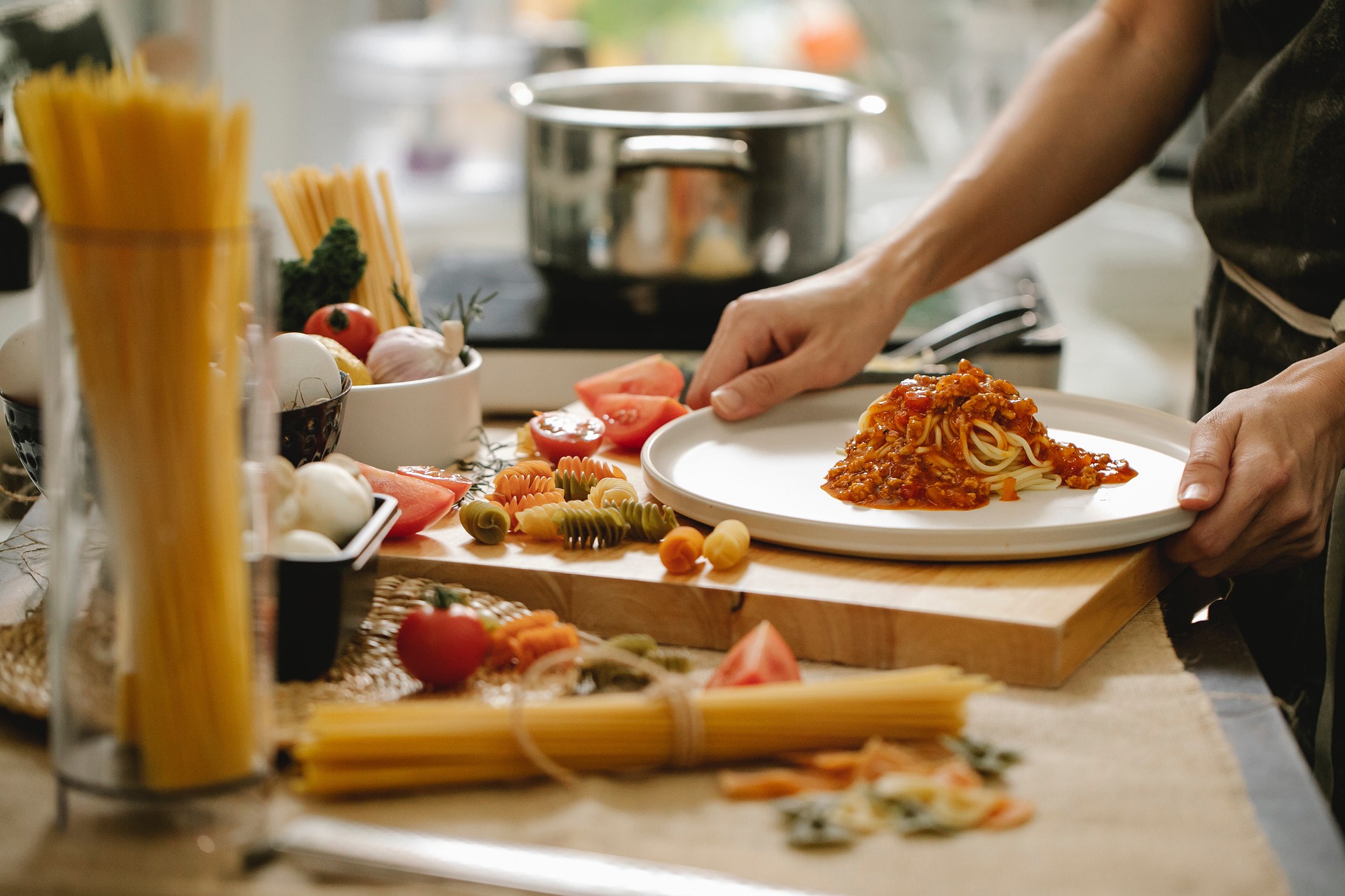 Person cooking spaghetti bolognese